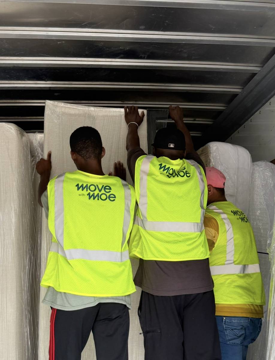 Three movers loading furniture into the truck