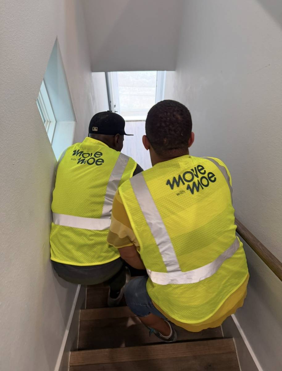 Movers carrying a load down a stairwell