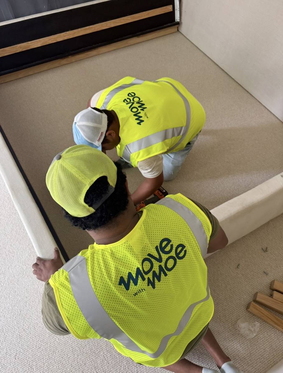 Two movers working together to lift a sofa