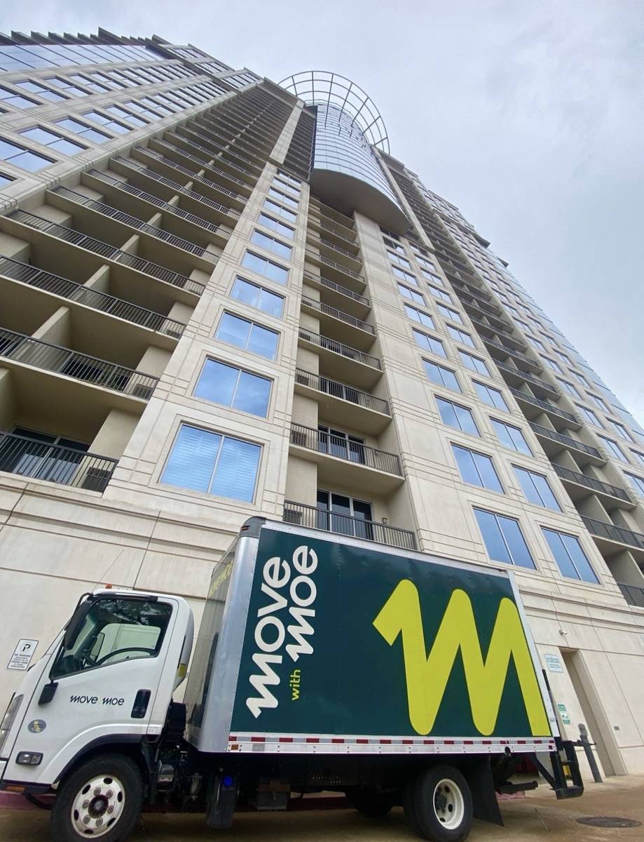 The Move with Moe truck outside a downtown high-rise
