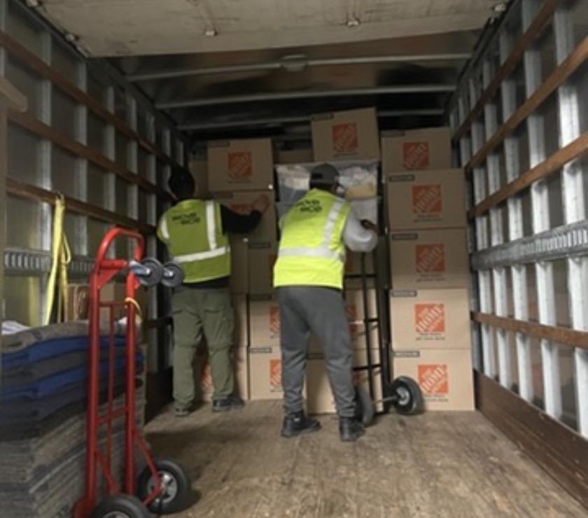 Two movers working together inside the loaded truck
