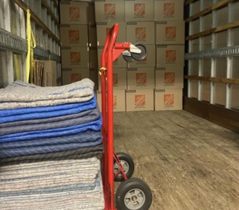 Moving blankets and a hand truck ready inside the truck